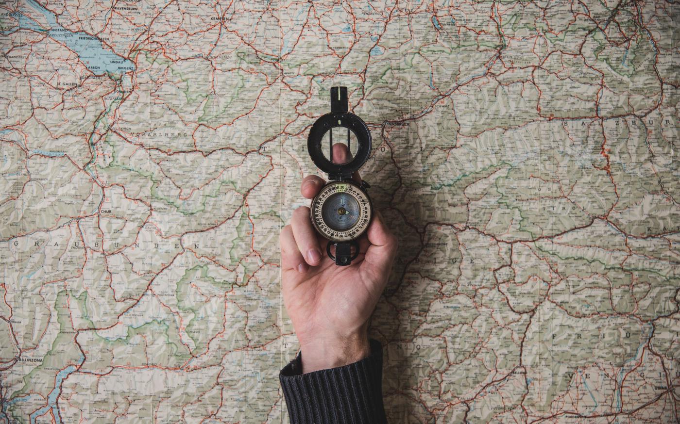 Compass held above a world map
